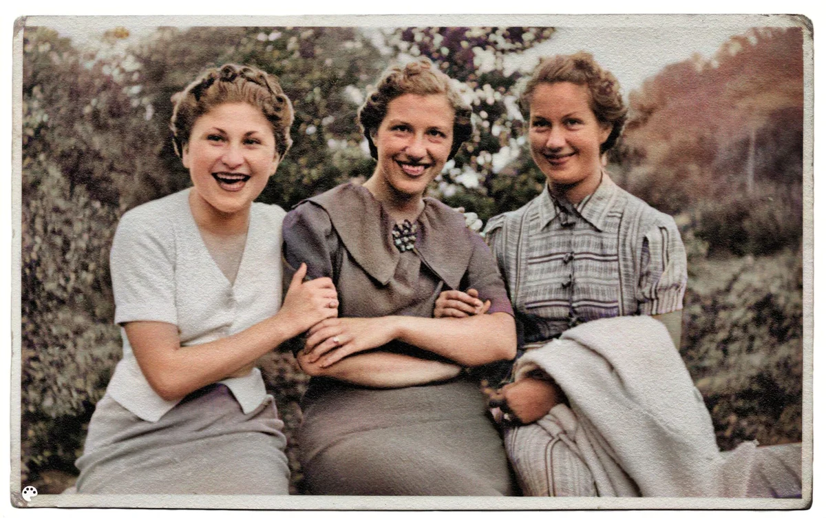 Три женщины сидят рядом на колоризованной фотографии